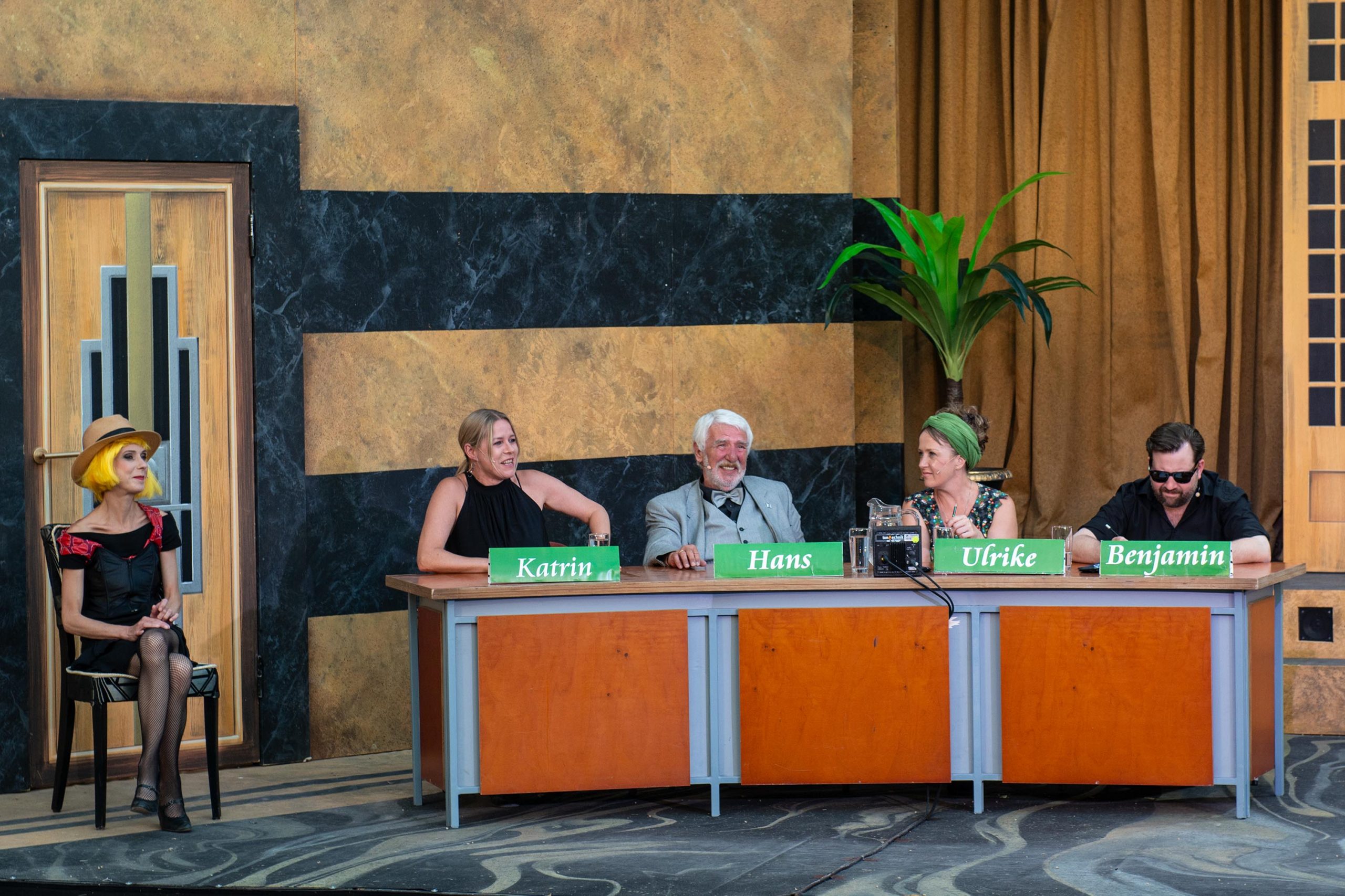 Das Rateteam mit Katrin, Hans, Ulrike und Benjamin in heiterer Stimmung sitzend an seinem Tisch.